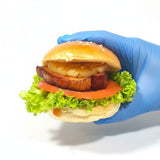 GRUB Singapore slider burger with grilled pineapple, thick pork patty, tomato, and lettuce on a sesame seed bun.