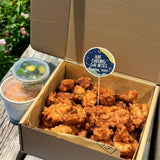 GRUB Singapore Har Cheong Gai Chicken Bites Box with sambal mayo and lime wedges. Crispy fried chicken pieces in a cardboard box.