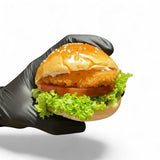 GRUB Singapore Crispy Fish Slider on a mini brioche bun with lettuce, tomato, and tartar mayo, held by a black gloved hand.