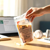 GRUB Singapore Iced Latte pouch with double espresso and fresh milk, held by a hand over a desk.