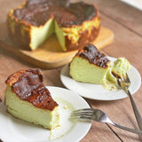 GRUB Singapore whole pandan burnt cheesecake with creamy centre and caramelised top, served on a wooden board and plates.