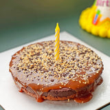GRUB Singapore Salted Caramel Chocolate Tart with dark chocolate ganache, salted caramel, hazelnut praline, and popping candy. One yellow candle.
