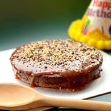 GRUB Singapore Salted Caramel Chocolate Tart with dark chocolate ganache, hazelnut praline, and popping candy. A birthday hat is in the background.