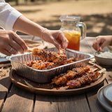 GRUB Singapore teriyaki chicken yakitori skewers with sesame seeds in a foil tray, served outdoors.